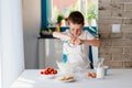 Child preparing cookies in kitchen