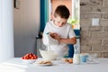 Child preparing cookies in kitchen