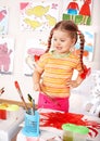 Child preschooler in orange draw picture.