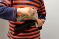 Child, preschooler, primary school student, puts money, banknotes, dollars, euros in a leather wallet, hands close-up