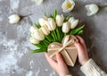 Child Presents Heart-Shaped Gift Box Amidst White Tulips for Mothers Day. Generative AI