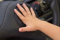 Child presses the horn in the car,The kid presses the signal button located on the steering wheel of the car Royalty Free Stock Photo