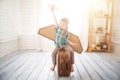 Child pretend to be pilot. Kid having fun at home. Summer vacation and travel concept. Little boy sits on a suitcase Royalty Free Stock Photo