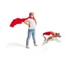 Child pretending to be a superhero with her super dog isolated on white studio background Royalty Free Stock Photo