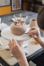 Child in the process of decorating the clay vase. Children pottery studio. Royalty Free Stock Photo
