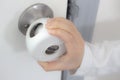 Child Proof Door Knob Covers over doorknob with a kid`s hand trying to open the door