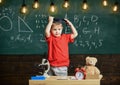 Child, pupil on smiling face near microscope. First former interested in studying, education. Kindergarten graduation