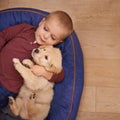 Child, puppy and hug with home, floor and pet with love at house. Kid, dog and golden retriever or sleepy labrador with