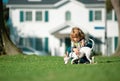 Child and puppy outside. Happy Kid boy and dog at backyard lawn. Pet care. Royalty Free Stock Photo