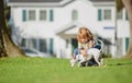 Child and puppy outside. Happy Kid boy and dog at backyard lawn. Pet care. Royalty Free Stock Photo
