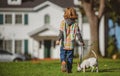 Child and puppy outside. Happy Kid boy and dog playing at backyard lawn. Pet walking. Royalty Free Stock Photo