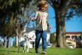 Child and puppy outside. Happy Kid boy and dog running at backyard lawn. Pet walking.