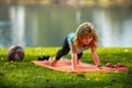 Child is pushing up on the green meadow, working out wearing sportswear, t-shirt outdoor. Kids doing push up outdoor Royalty Free Stock Photo