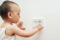 Child put finger in socket. Baby touching the power socket