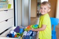 The child puts his clothes on. The boy pulls the T-shirt out of