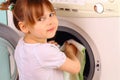 Child puts the towels in the washing machine Royalty Free Stock Photo