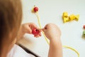 Child putting beads on a string. Bead stringing activity. Fine motor skills development Royalty Free Stock Photo