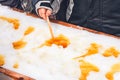 Child putting maple taffy on a wooden stick Royalty Free Stock Photo