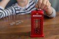 child putting money to the coin box look like traditional british call box, saving money concept Royalty Free Stock Photo