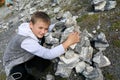 Child putting stones in heap in marble canyon Royalty Free Stock Photo