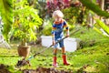 Child and rake in autumn garden. Kid raking leaves Royalty Free Stock Photo