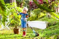 Child and rake in autumn garden. Kid raking leaves Royalty Free Stock Photo