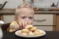 Child reaches for cookie and looks at the camera Royalty Free Stock Photo