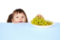 Child reaches for grapes lying on table