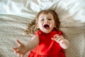 The child reaches up, cries and calls. Emotional cute baby girl in a bad mood, angry and sad. lying on the bed.asks for help, Top Royalty Free Stock Photo