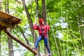 Child reaching platform climbing in high rope course