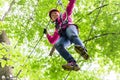 Child reaching platform climbing in high rope course