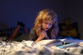 Child reading a book in bed before going to sleep. Child reading a book on bedtime night. Boy reading bedtime story Royalty Free Stock Photo