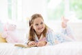 Child reading book in bed. Kids read in bedroom Royalty Free Stock Photo