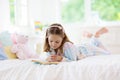 Child reading book in bed. Kids read in bedroom Royalty Free Stock Photo