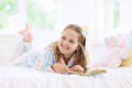 Child reading book in bed. Kids read in bedroom Royalty Free Stock Photo