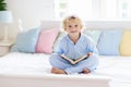 Child reading book in bed. Kids read in bedroom Royalty Free Stock Photo