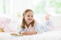 Child reading book in bed. Kids read in bedroom Royalty Free Stock Photo