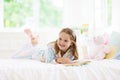 Child reading book in bed. Kids read in bedroom Royalty Free Stock Photo