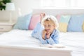 Child reading book in bed. Kids read in bedroom Royalty Free Stock Photo