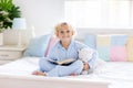 Child reading book in bed. Kids read in bedroom Royalty Free Stock Photo