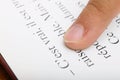 Child reading with his finger on dictionary