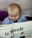 Child reading Le Monde newspaper Royalty Free Stock Photo