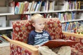 Child reading a library book on a couch Royalty Free Stock Photo