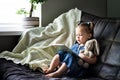 Child reading. Little cute girl 1-3 is reading a book with a toy plush hare sitting on a sofa Royalty Free Stock Photo