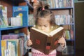 Child reading magic book. little girl in laibrary looking into fairy tale. wonder of education Royalty Free Stock Photo
