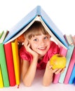 Child reading open book on table.