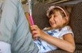 Cute girl kid using iPad digital computer tablet on bed for education or playing game. Royalty Free Stock Photo