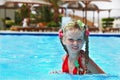 Child in red bikini and glasses swimming.