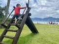 Ilhabela Beach, Sao Sebastiao, Brazil: 05 january 2023: child in a red blouse climbing the stairs of a slide Royalty Free Stock Photo