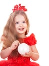 Child in red dress holding christmas ball. Royalty Free Stock Photo